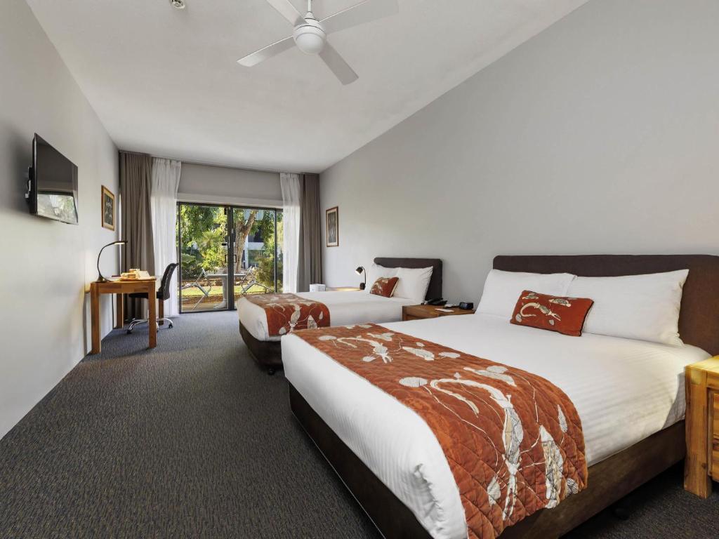 Una habitación de hotel con dos camas y una ventana. en Mercure Kakadu Crocodile, en Jabiru