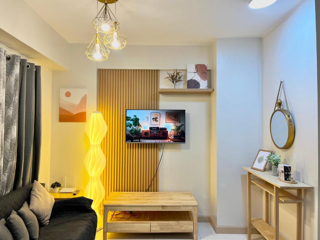 a living room with a couch and a tv on a wall at Modern 2br Unit in Davao in Davao City