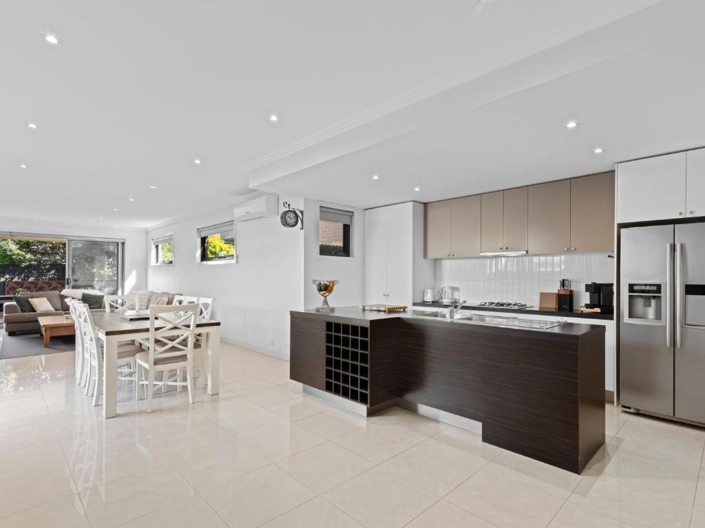 an open kitchen and living room with a table and chairs at Time Out on Flinders in Indented Head