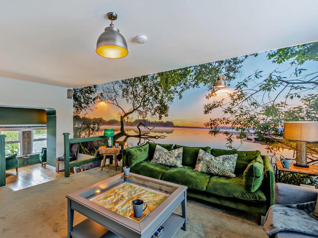 a living room with a green couch and a painting on the wall at 2 Bed in Hawkshead 93167 in Hawkshead