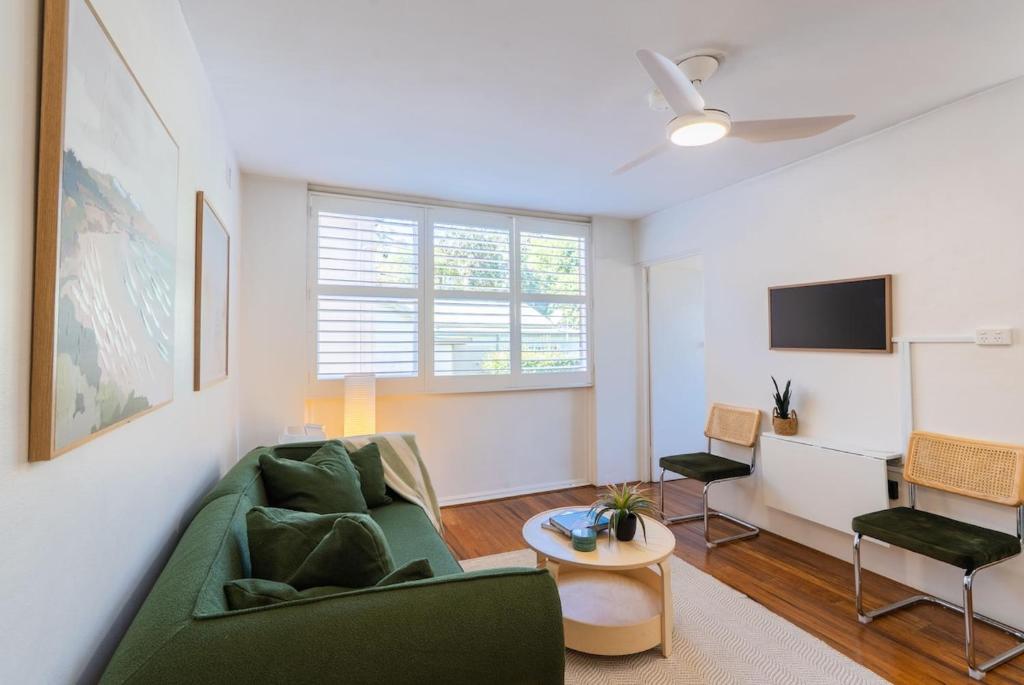 - un salon avec un canapé vert et une télévision dans l'établissement Freshwater Coastal Hideaway - 1 bedroom sleeps 4, à Sydney