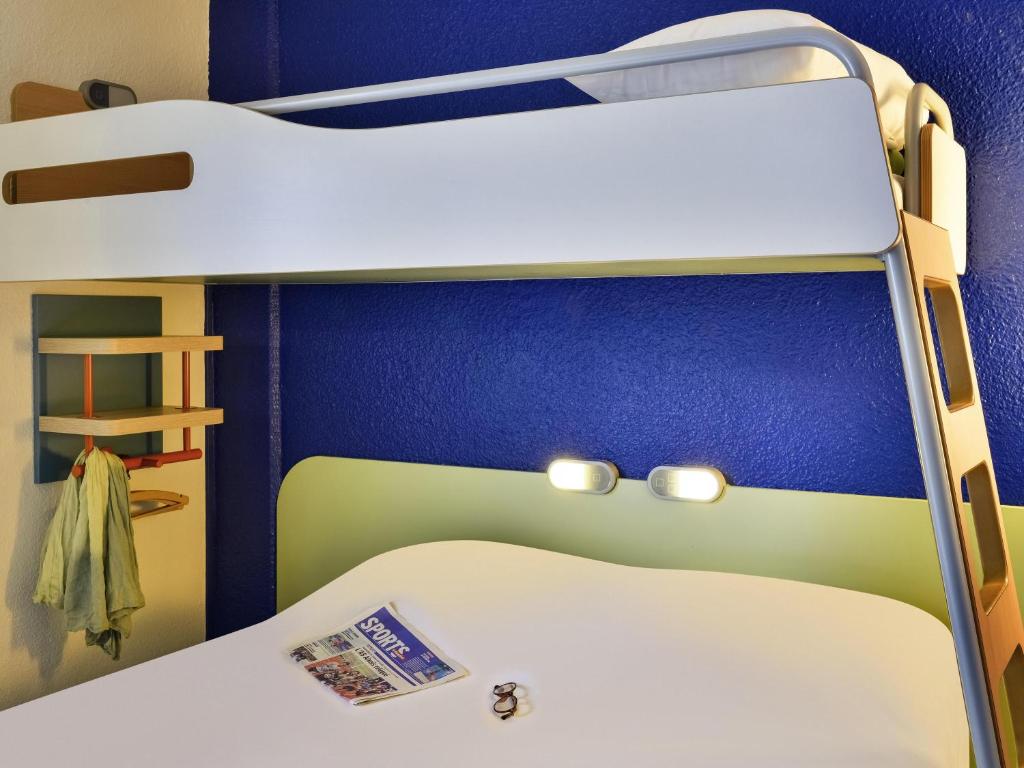 a bedroom with two bunk beds and a blue wall at ibis budget Versailles - Trappes in Trappes