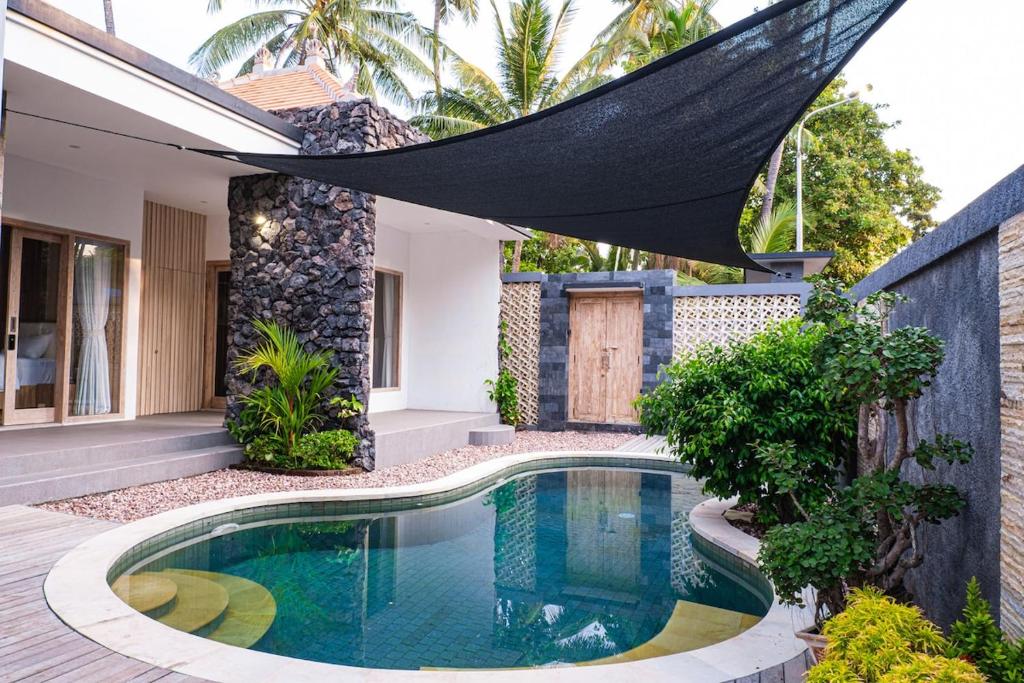 a swimming pool in the backyard of a house at Villa D'Ling in Tianyar