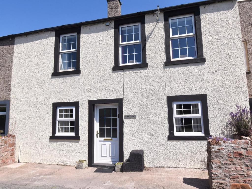 a white house with black windows and a white door at 4 Bed in Gosforth 85807 in Gosforth