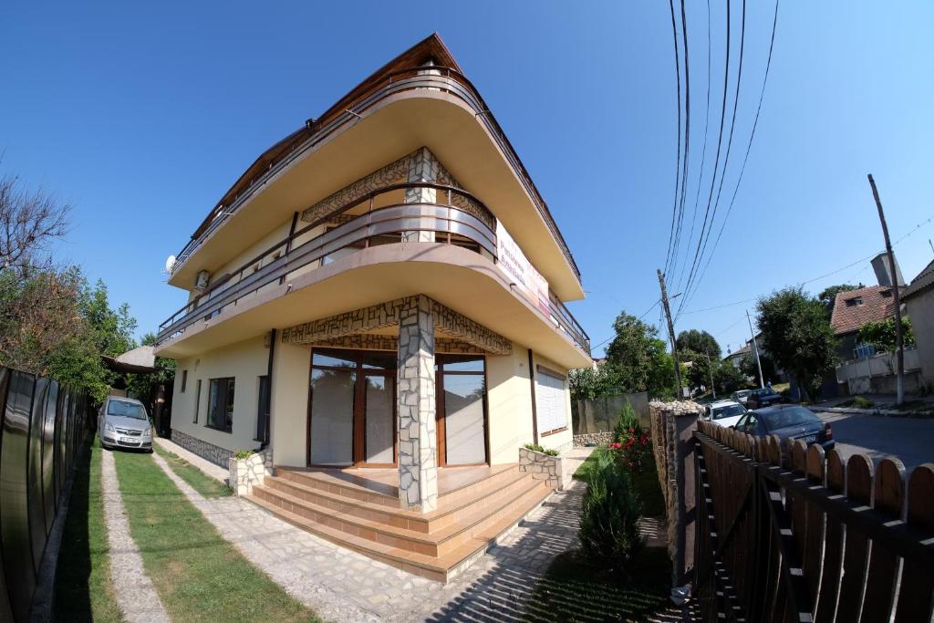 a house with a large porch and a balcony at Pensiunea Anastasia in Jurilovca