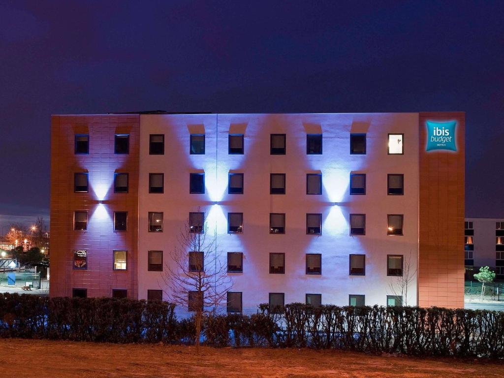 Un edificio con luces en el costado. en ibis budget Toulouse Aeroport, en Blagnac