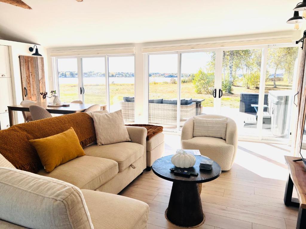 un salon avec un canapé, des chaises et une table dans l'établissement Waterfront Cottage ''The Dream'' with Private Hot Tub, à Shediac