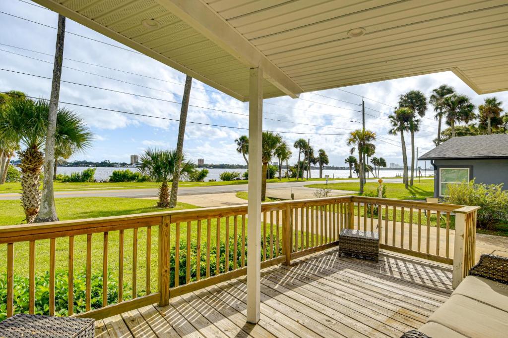 a porch with a wooden railing with palm trees at 3 Mi to Beach and Boardwalk Riverfront Daytona Home in Holly Hill