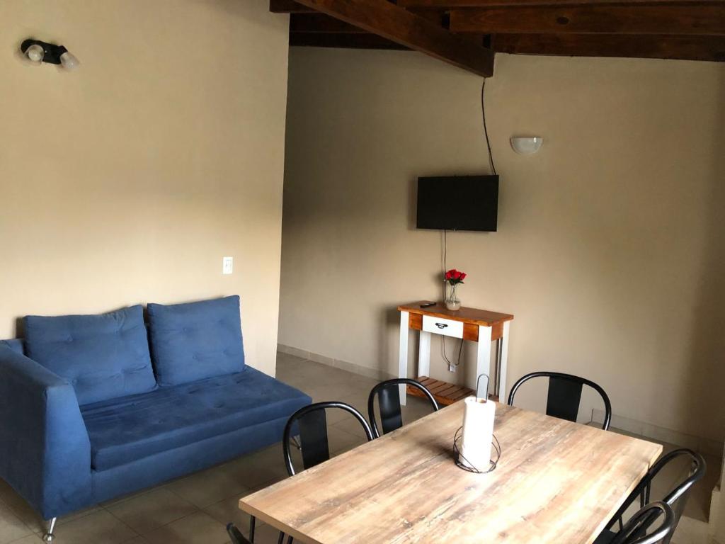 un salon avec un canapé bleu et une table dans l'établissement Departamento Patagonia Alegre, à Puerto Madryn