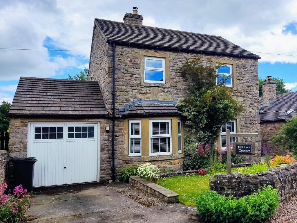 Redmireにある3 Bed in Leyburn 94415の白いガレージ付きのレンガ造りの家