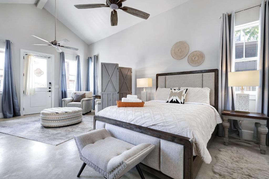 a bedroom with a large bed and a chair at Brazos - A Birdy Vacation Rental in Fredericksburg