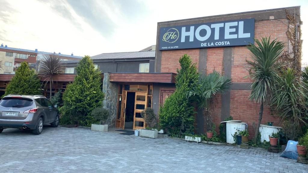 a hotel with a car parked in a parking lot at Hotel de la Costa in Talcahuano