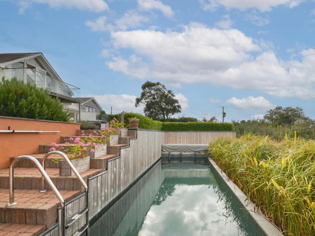 a swimming pool with stairs leading into a yard at 4 Bed in Wembury 54383 in Wembury