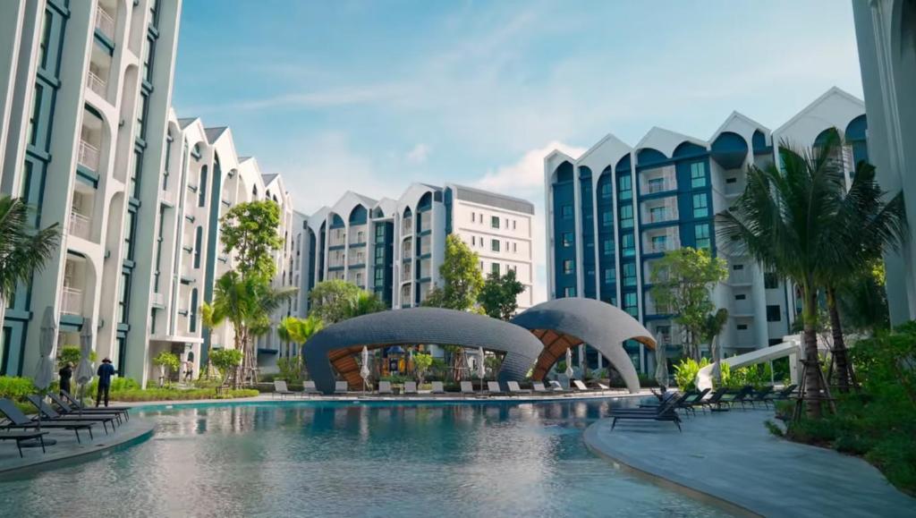 una piscina nel centro di una città con edifici di Title HALO 1 - Modern 1BR Pool View Walk to Nai Yang Beach a Nai Yang Beach