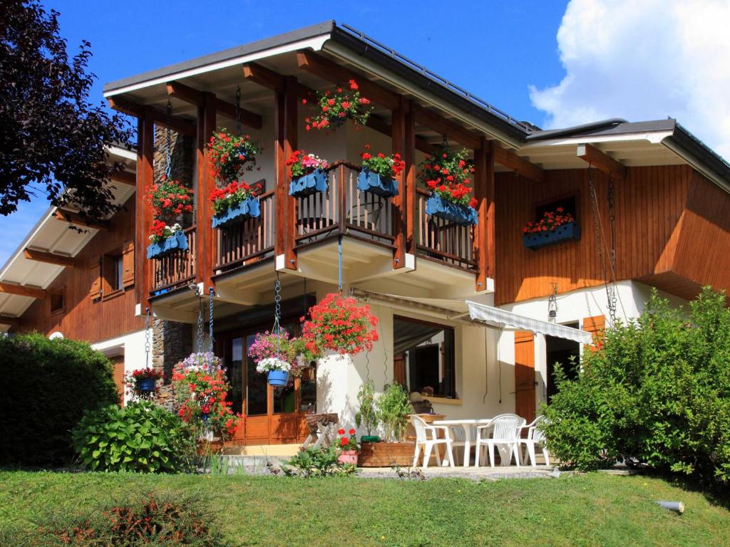 ein Haus mit Blumen auf den Balkonen und Tischen in der Unterkunft Charmante Villa à Samoëns avec Wifi et 2 Chambres - FR-1-846-34 in Samoëns