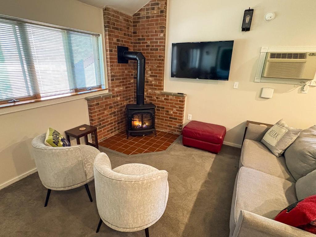 a living room with a couch and a fireplace at Cozy Attitash Getaway-1BR-Pool-Walk to Attitash in Bartlett