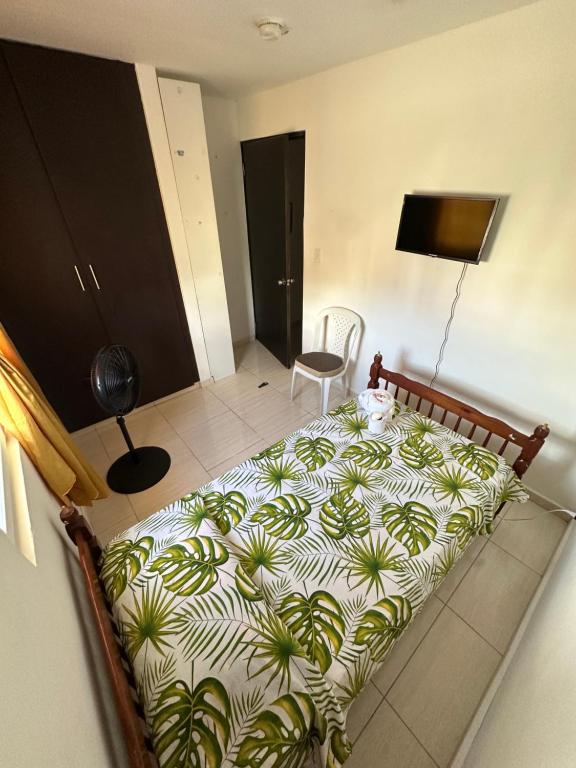 ein Schlafzimmer mit einem großen Bett mit Bettwäsche im Pflanzenmuster in der Unterkunft Cuarto amoblado, Arraijan 