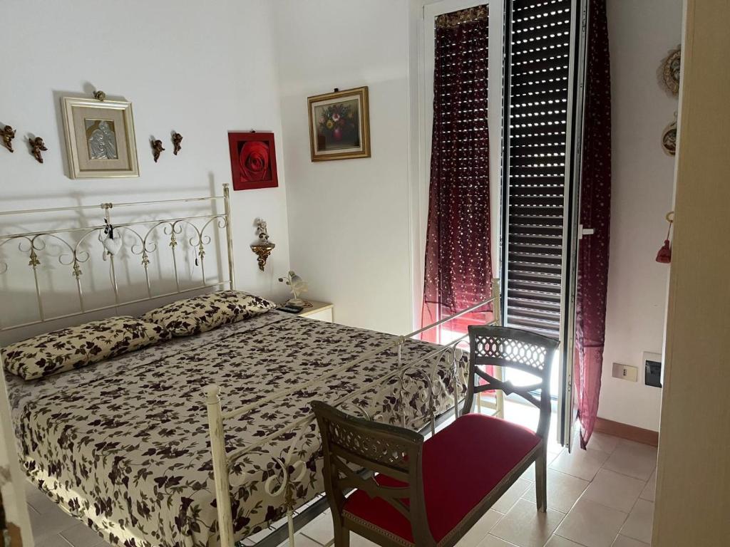 a bedroom with a bed and a chair and a window at Appartamento a 20 metri dal mare San Salvo Marina in Marina di Montenero