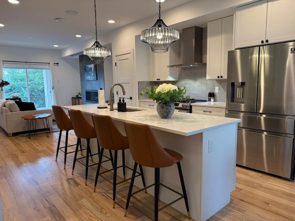 a kitchen with a large island with bar stools at Cozy 3 Bedroom Denver Home by Mile High Stadium and Downtown! in Denver