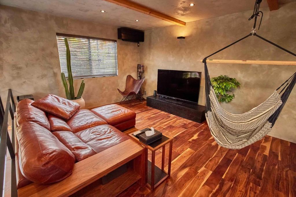 a living room with a couch and a hammock at COCO VILLA 九十九里一宮-Sauna- in Ichigaya
