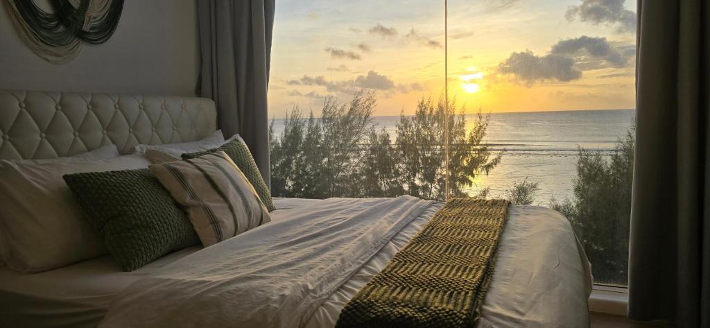 a bedroom with a bed with a view of the ocean at Nala Host- 2BR Beachfront Apartment in Male City