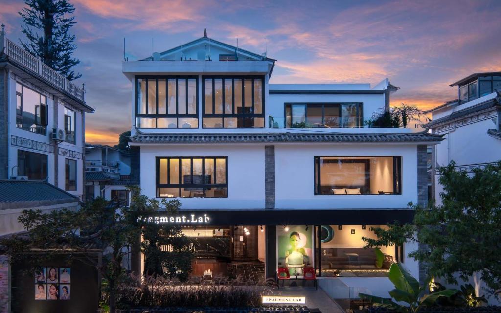 a large white house with a sunset in the background at Wangye Homestay Collection, Dali Ancient Town in Dali Ancient Town