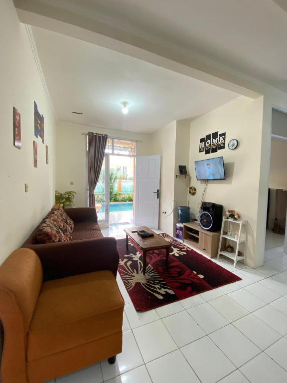 a living room with a couch and a table at Villa Fathan in Tjiandjur
