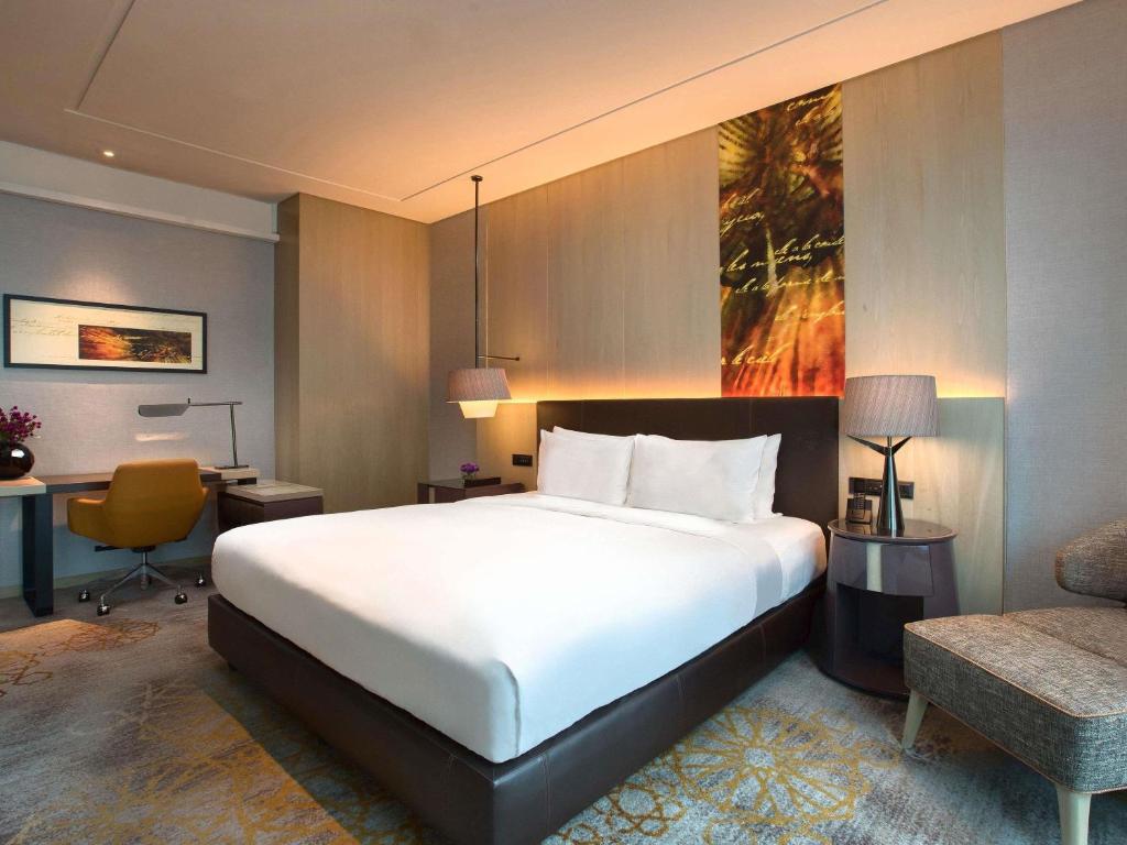 A large bed and a dedicated desk share a warm, contemporary bedroom.