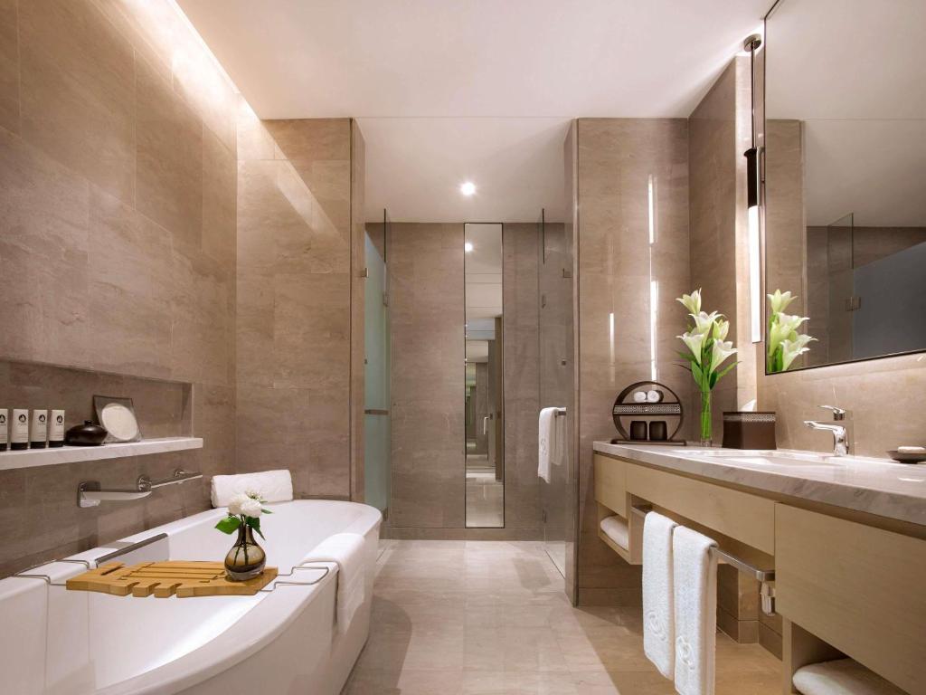 A marble-finished bathroom with a soaking tub, walk-in shower, and double vanity.