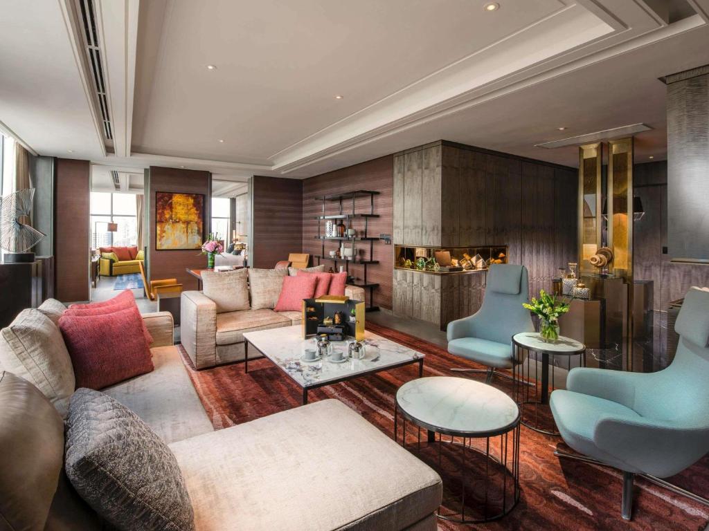 A polished lounge with sofas, armchairs and a fireplace.