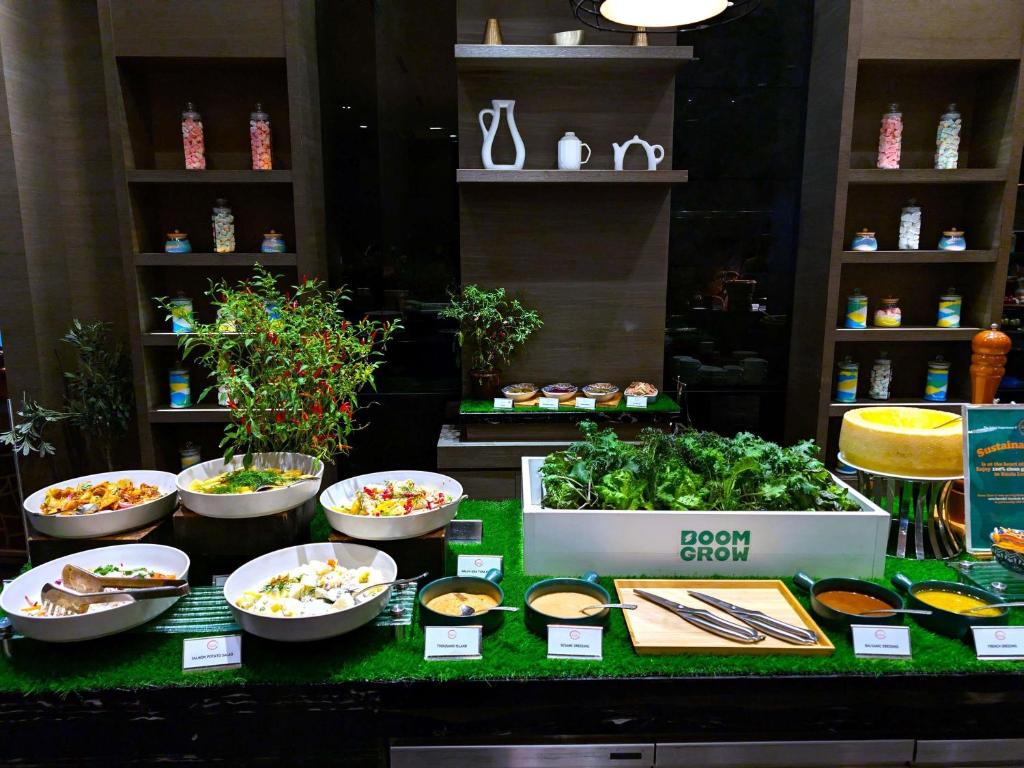A salad and vegetable buffet with labelled bowls, dressings, and a grow-themed display.