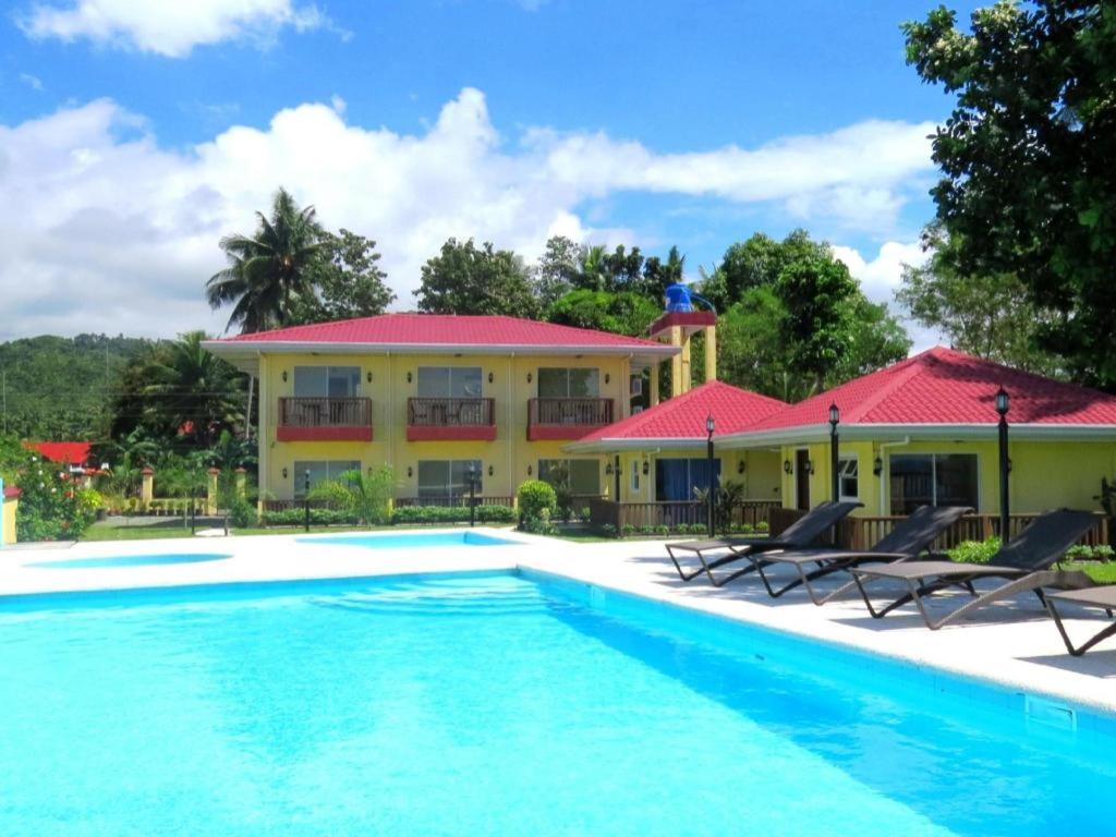 a resort with a swimming pool in front of a building at Caimito Beach Hotel in Ichon