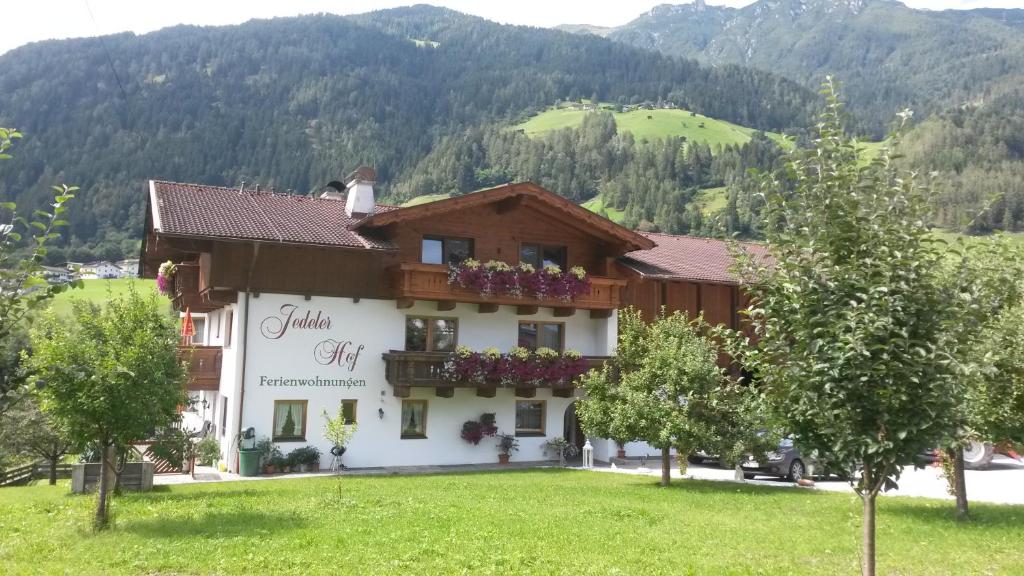 a building in a field with mountains in the background at Jedelerhof in Neustift im Stubaital