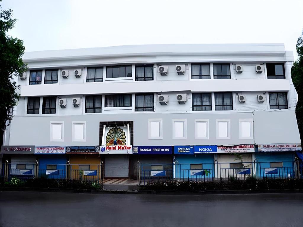a large white building with windows and balconies at Mayor Hotel in Siliguri