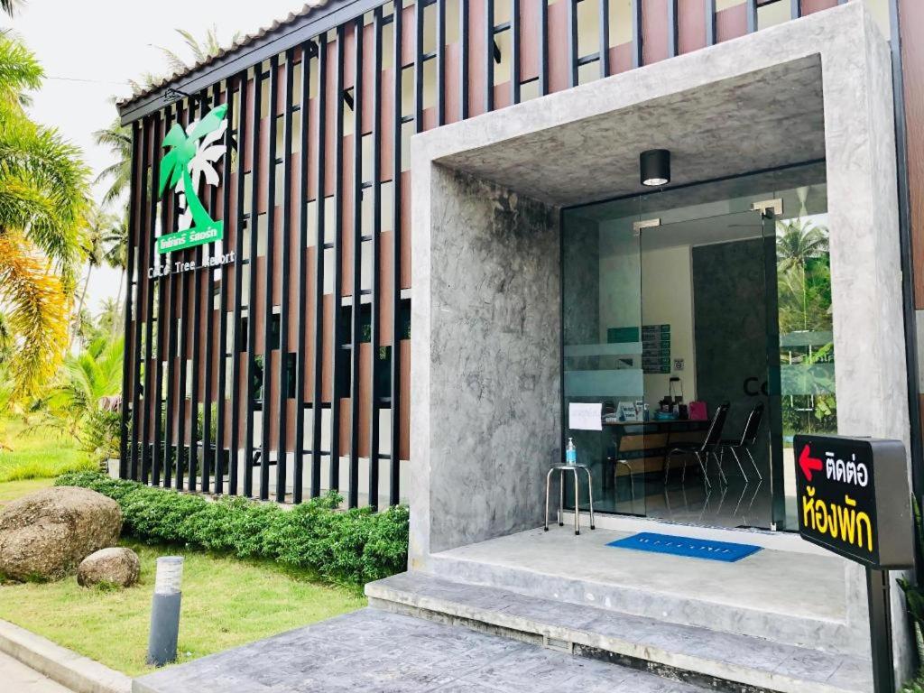 a building with a sign in front of it at CoCo Tree Resort in Thap Sakae