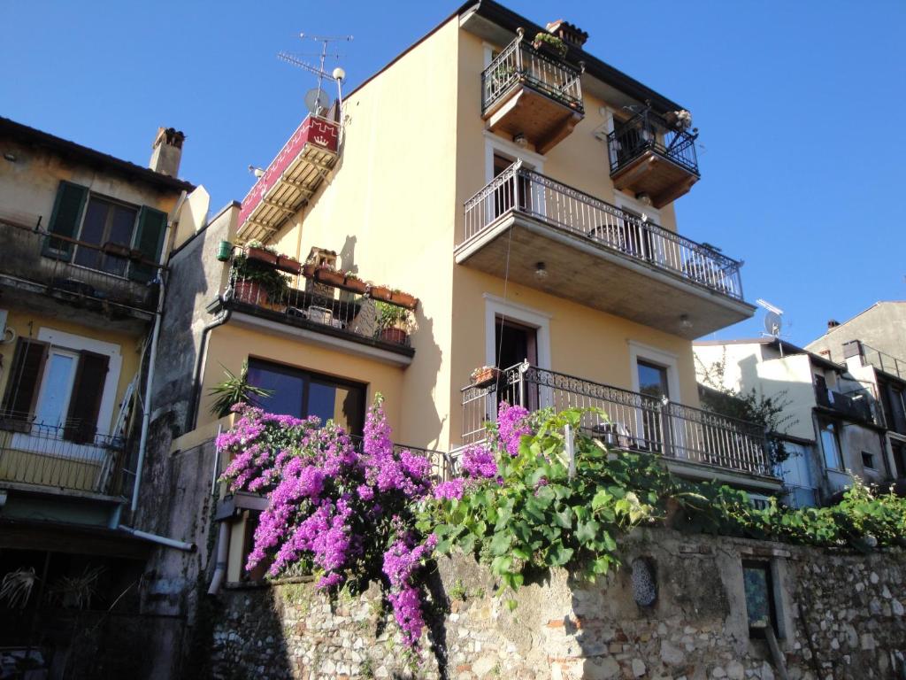 un edificio con flores a un lado. en The Queen Tower, en Desenzano del Garda