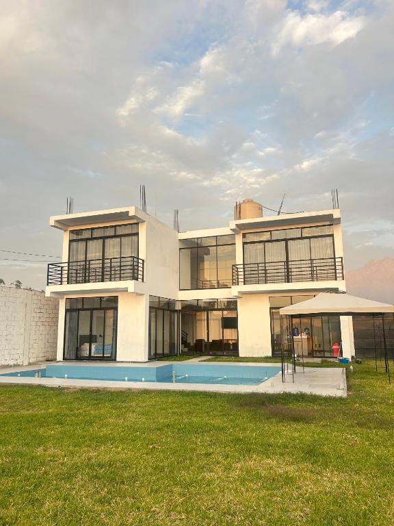 a large house with a swimming pool in front of it at Casa Laguna in Trujillo