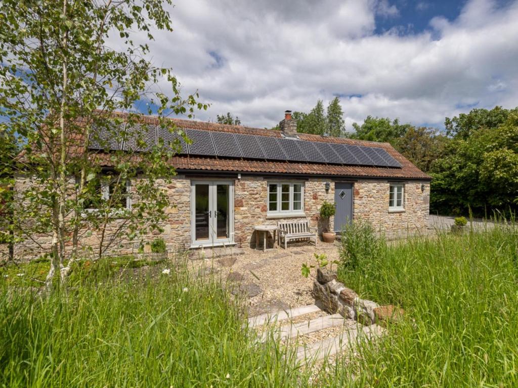 a stone house with solar panels on the roof at 1 Bed in Wedmore CRIBB in Wedmore
