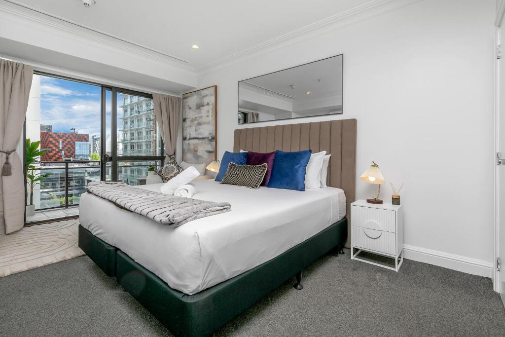 a bedroom with a large bed and a large window at Sky Tower View with Rooftop Pool! in Auckland