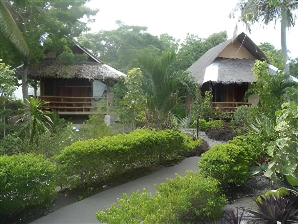 a resort with two huts and a walkway at Mayas Native Garden Resort in Basdiot