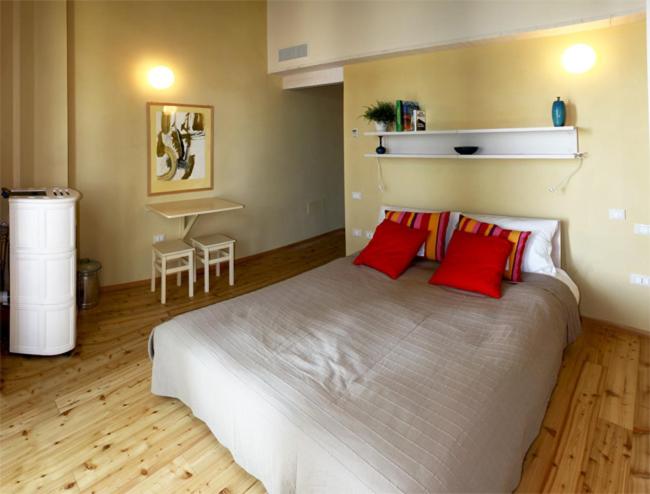 una camera da letto con un grande letto con cuscini rossi di Agriturismo Gallegati a Faenza