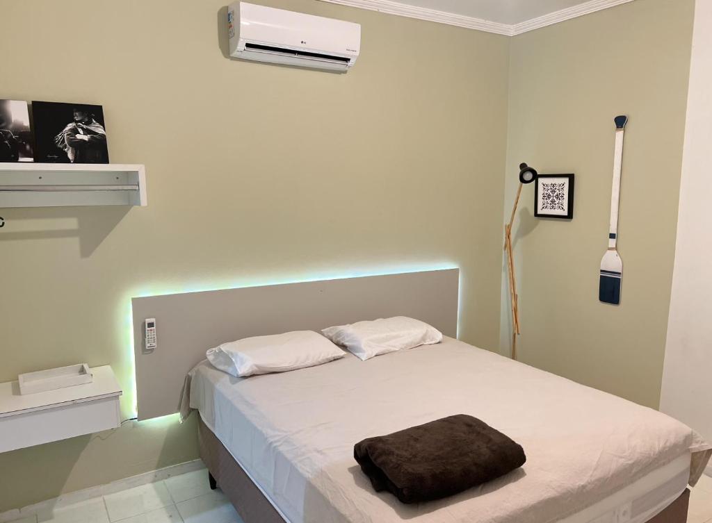 ein Schlafzimmer mit einem Bett mit einem braunen Kissen darauf in der Unterkunft Casa De Ferias No Centro De Caldas Novas in Caldas Novas