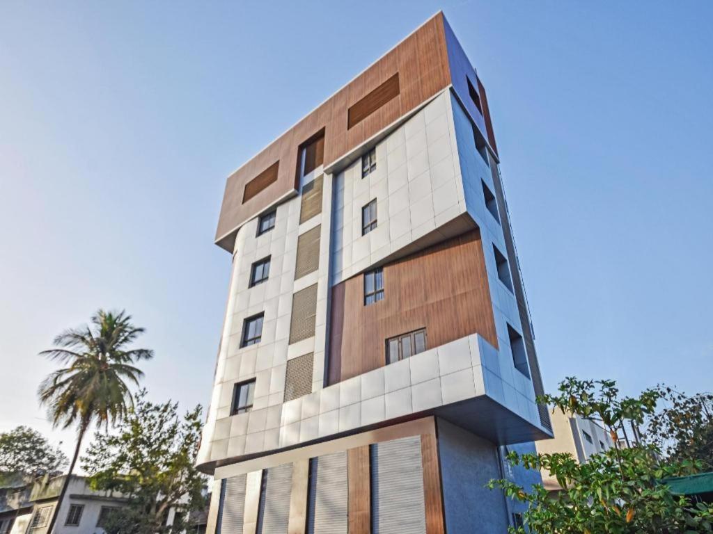 a tall building with a palm tree in front of it at Flagship The Address in Deolāli