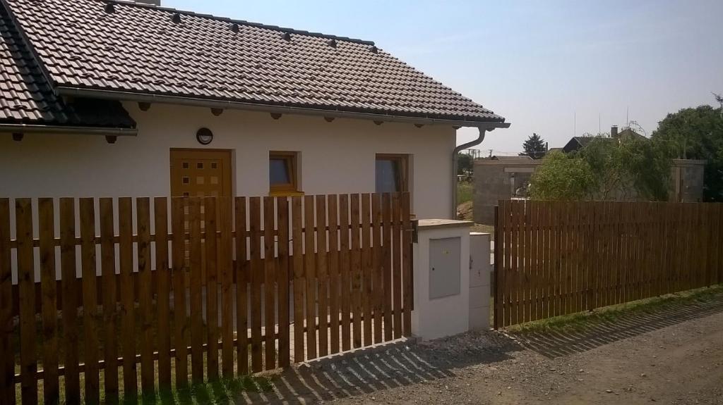 una casa detrás de una valla de madera con una puerta en Jendův domeček, en Velká Jesenice