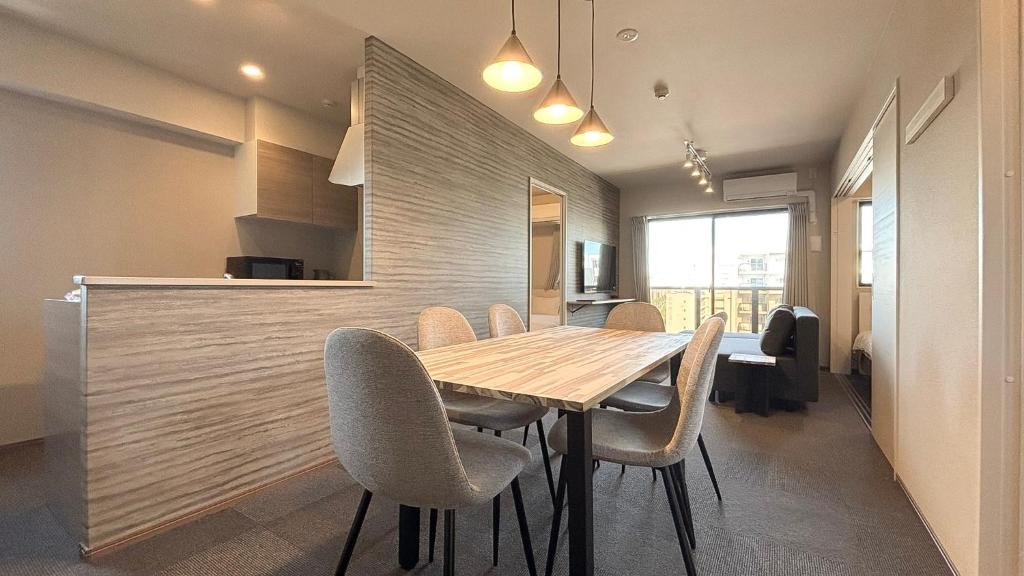 福岡市にあるLiving like hotel Hakata Premiumの木製のテーブルと椅子のあるダイニングルーム