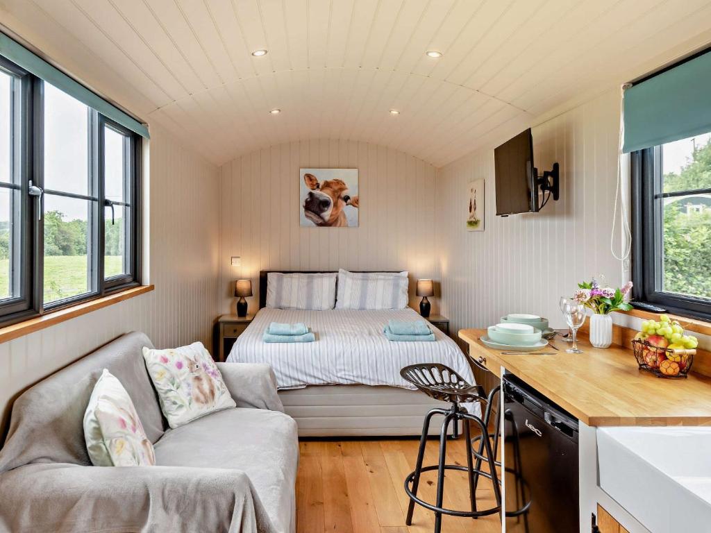 a small bedroom with a bed and a couch and a table at 1 Bed in Uplowman 96190 in Uplowman