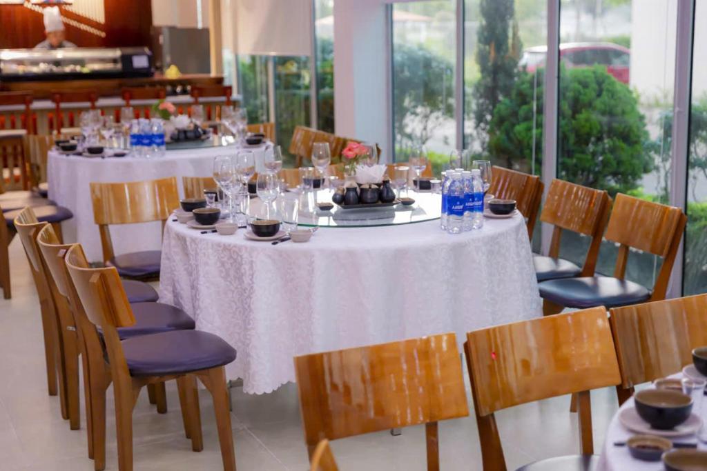 a dining room with tables and chairs with wine glasses at Juna hotel - Condotel in Thanh Hóa