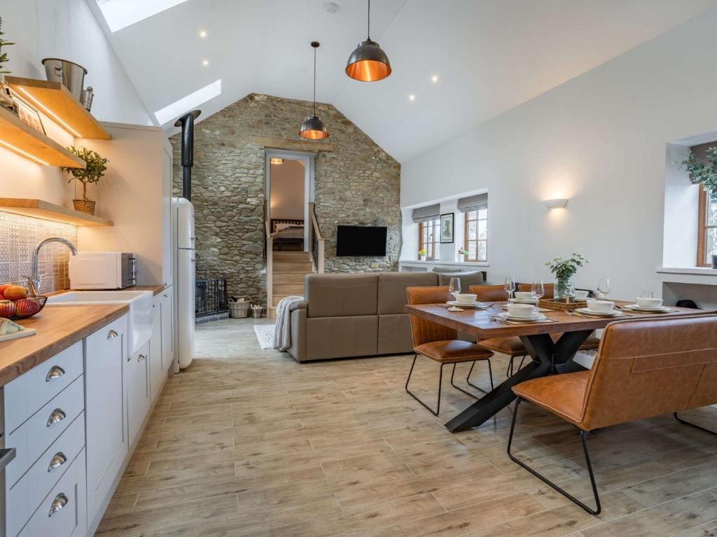 a kitchen and living room with a table and a couch at 3 bed in Llandysul 87071 in Pencader