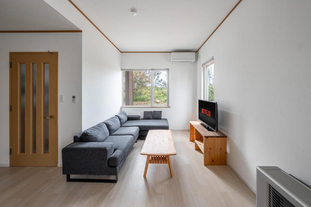a living room with a couch and a tv at Toya Serenity Stay in Lake Toya