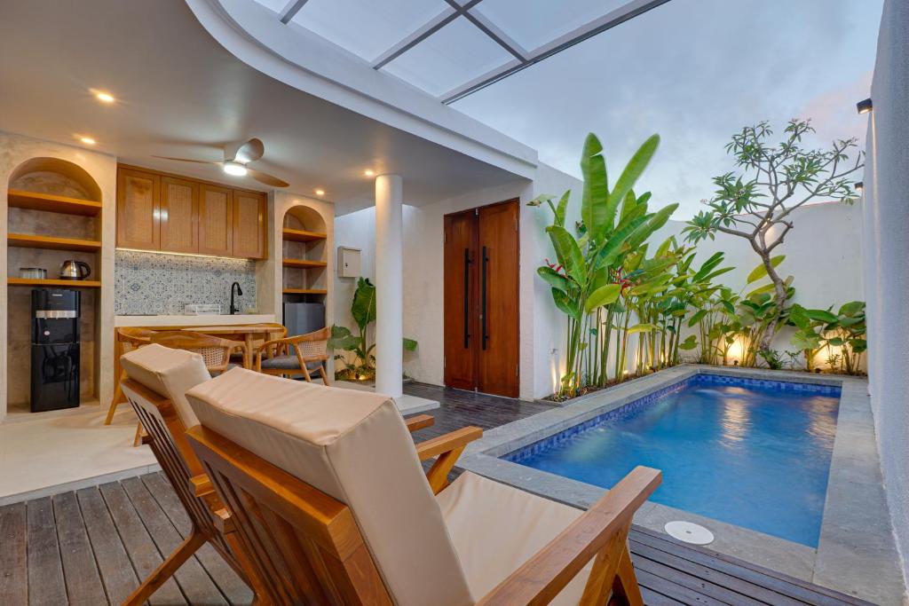 an indoor swimming pool in a kitchen and living room with a table and chairs at Sweet Escape 1BR Matahari LaLuxe A22 Sanur Villa in Sanur